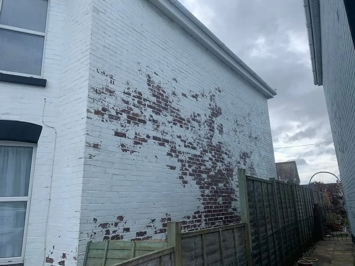 Peeling paint on a brick wall before redecoration in Camelford
