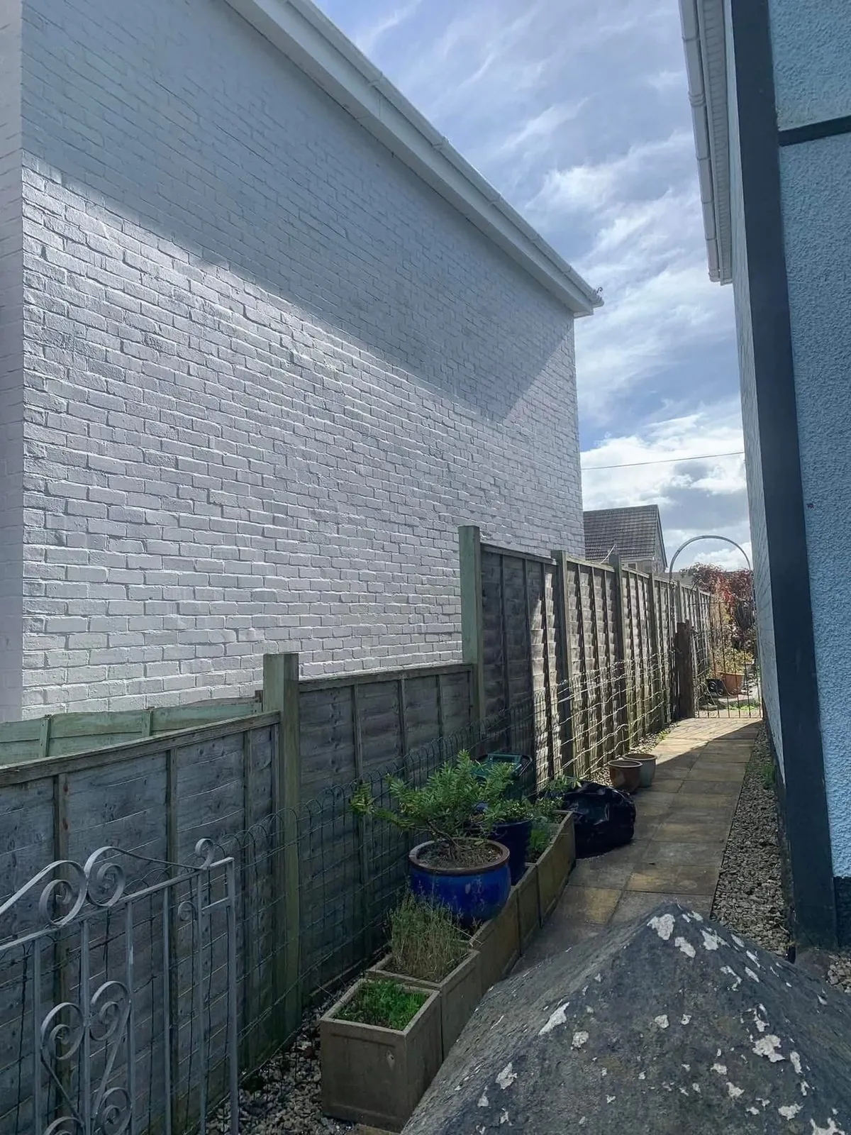 Freshly painted brick wall after preparation and masonry paint in Camelford